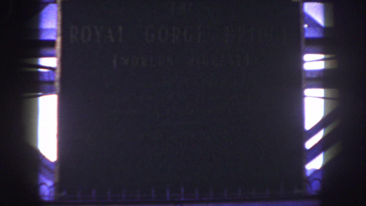Royal Gorge Bridge plaque filling the frame with bright side openings and dark supports.