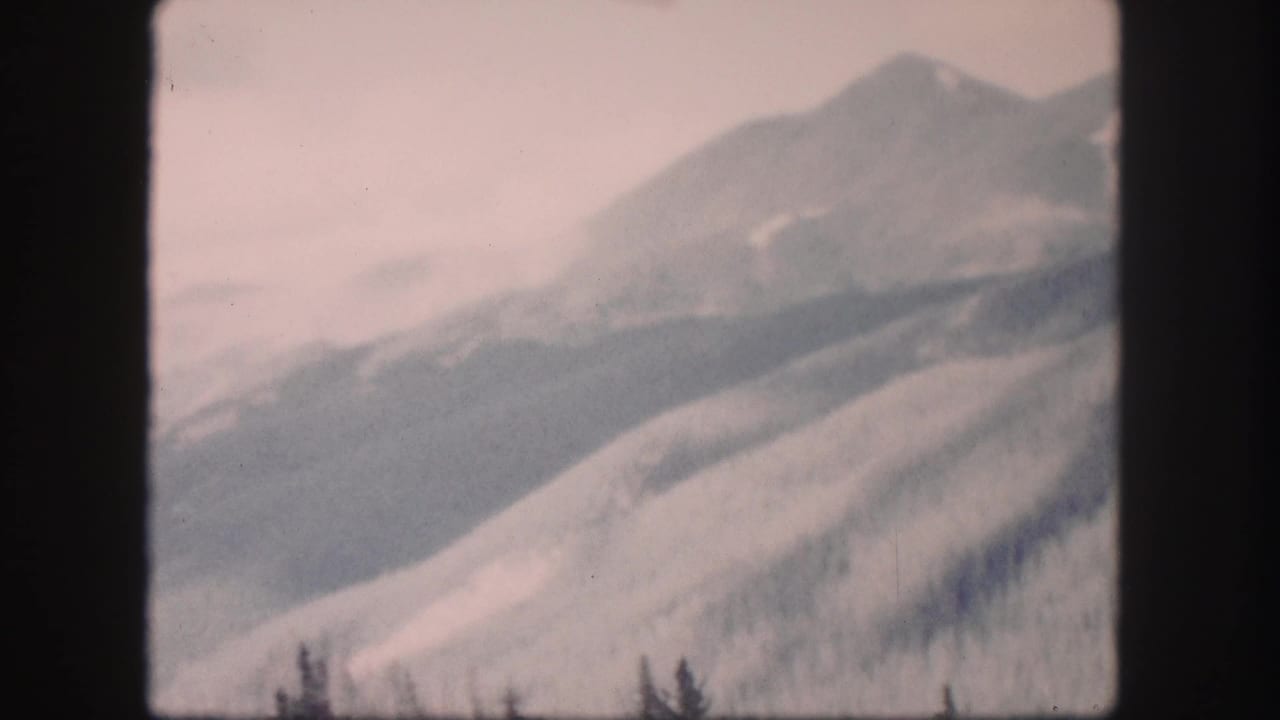 Soft mountain ridges fill the frame beneath a pale sky.