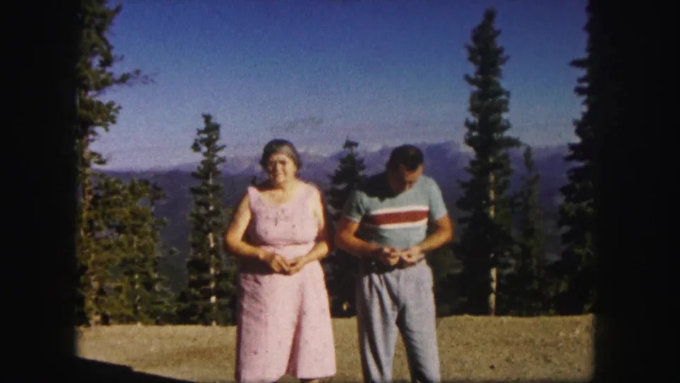 At a Colorado mountain overlook, the older woman faces forward as the man examines a small object in his hands.