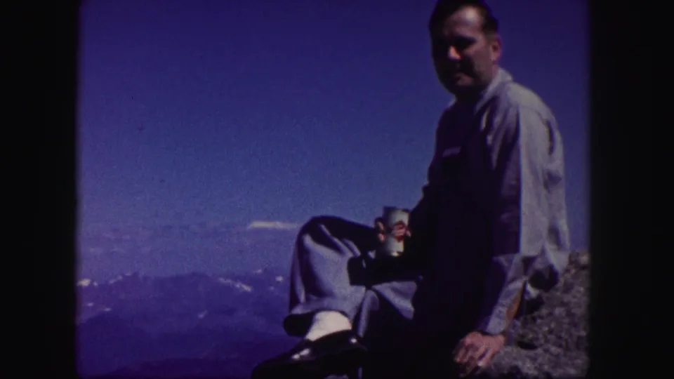 A darker 8mm frame shows the man seated on the rock with a beverage can, silhouetted against a blue Colorado mountain landscape.