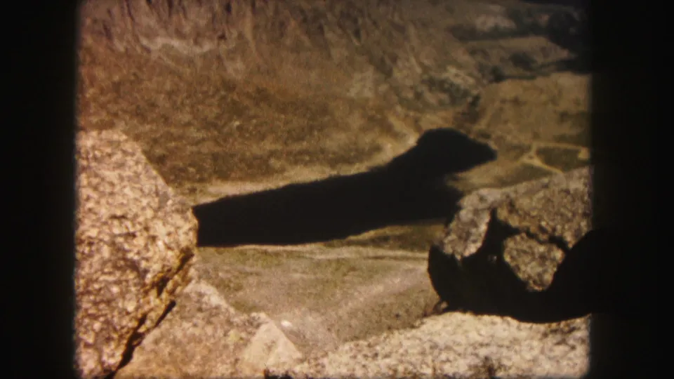 The final frame shows boulders and a broad shadow across a Colorado mountain overlook in 1958 home-movie color.