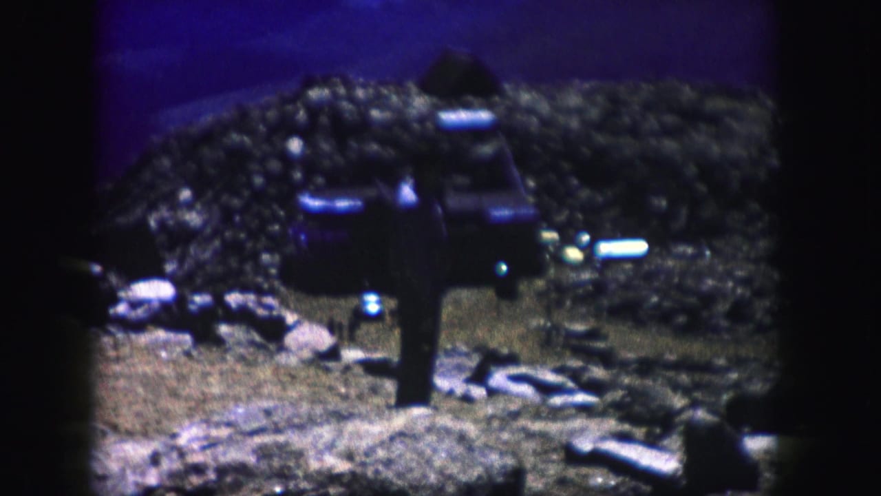 Color-shifted 8mm view of a person standing with their back to the camera in a rocky Colorado landscape.