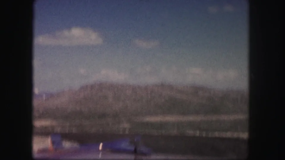 Soft 8mm view of a Colorado ridge and roadside foreground during a mountain drive in 1958.