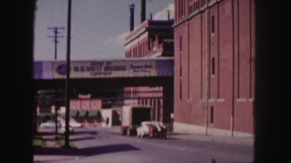 1958 Denver view of a quiet industrial block with vehicles under Goetz Brewing and Country Club beer signage.