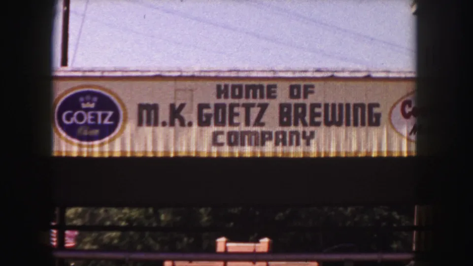 1958 Denver 8mm still showing the Goetz brewery facade sign, circular logo, and dark frame edges from the home-movie scan.