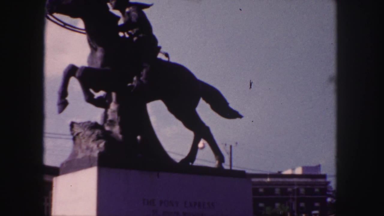 Equestrian statue in dark silhouette with the monument base and sky visible.