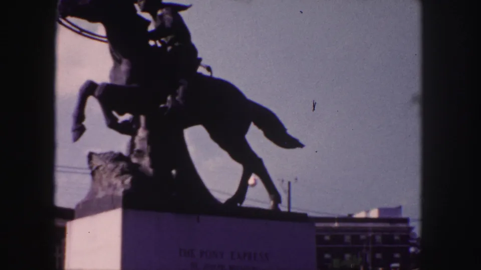 The Denver Pony Express statue remains centered in silhouette, with base lettering faintly visible below the horse.