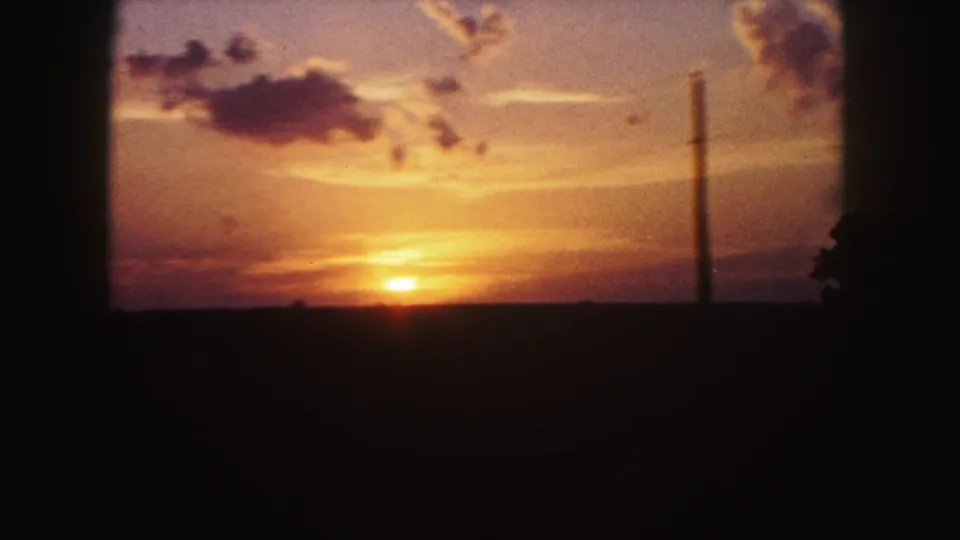 The final 1958 Denver-area frame shows the sun at the horizon, orange clouds, dark land, and a slim roadside pole.