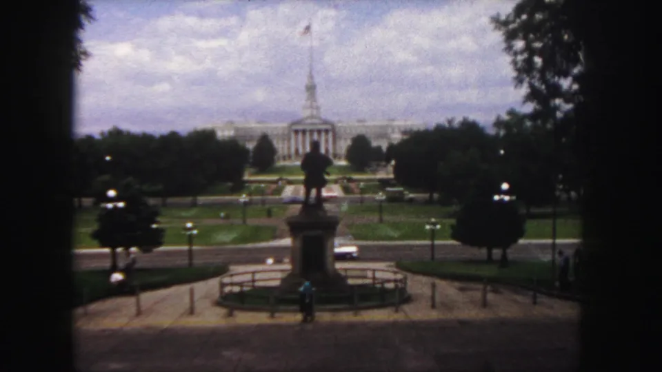 Denver, 1958: a statue overlooks a formal plaza toward a classical public building with a flag-topped spire.