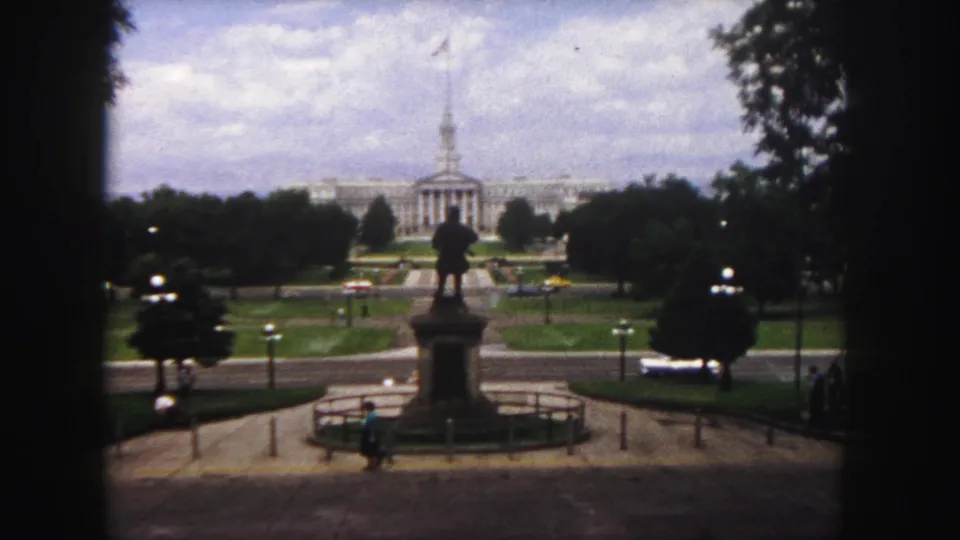 Denver, 1958: the camera holds on a central statue, landscaped civic grounds and a distant classical building.