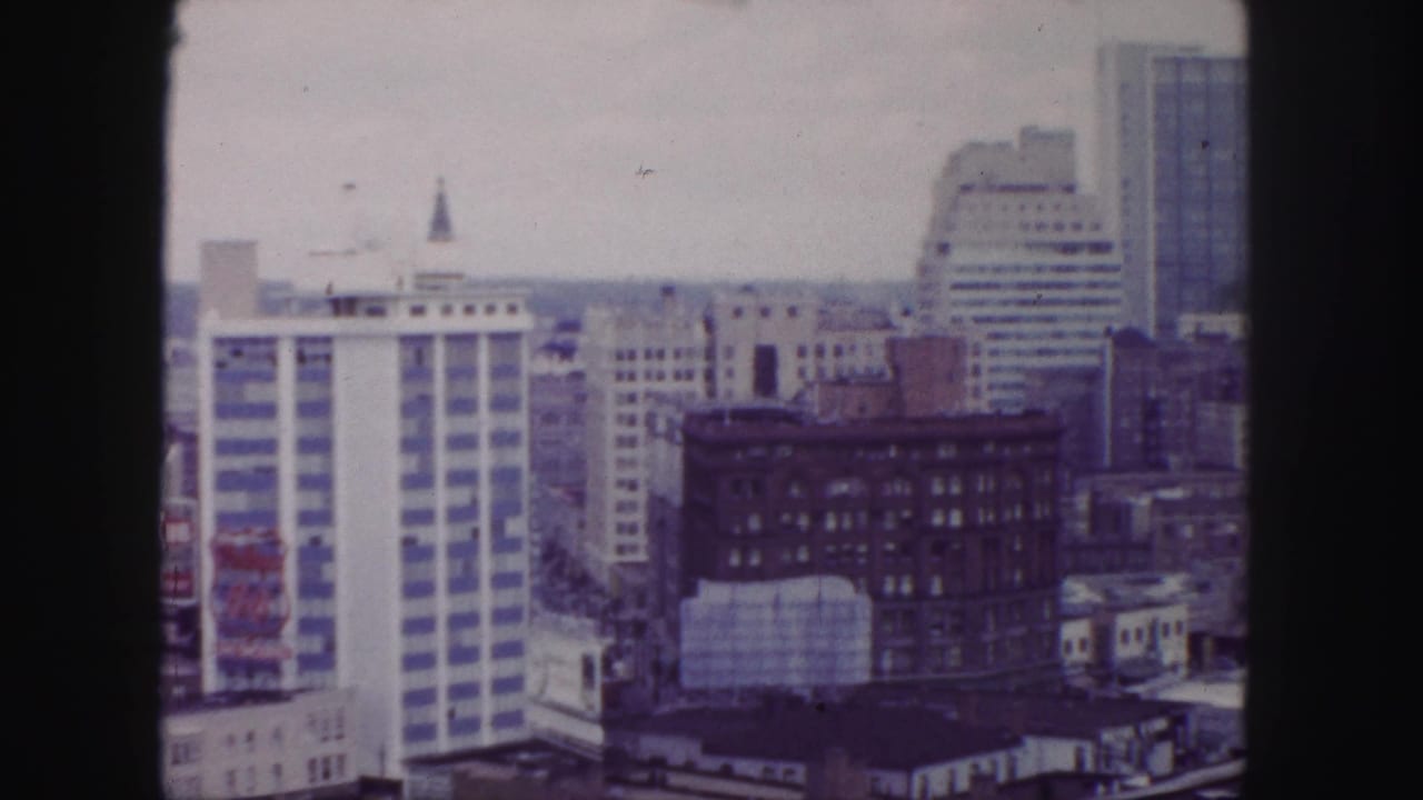 1958 Denver downtown skyline with a white striped tower, masonry buildings, and distant horizon seen from an elevated vantage.