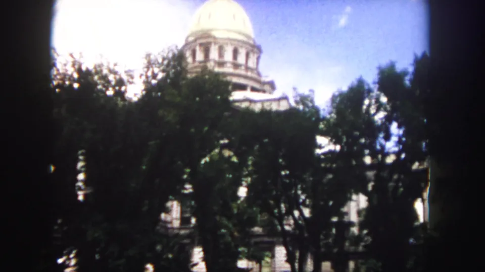 A closer 1958 Denver view shows the white capitol dome above trees, with the facade mostly screened by foliage.