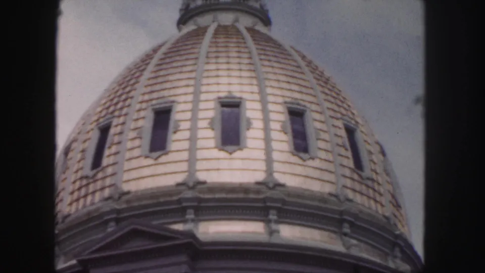 1958 Denver home-movie frame showing the dome at close range, with visible windows, roof ribs, and a small pediment below.