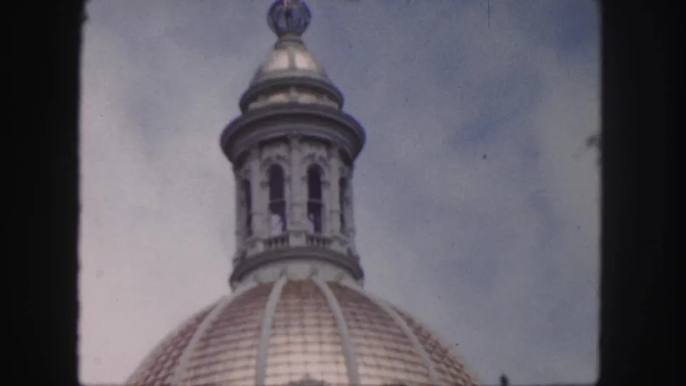 1958 Denver frame showing the dome's lantern cupola and tiled roofline in a steady upward architectural view.