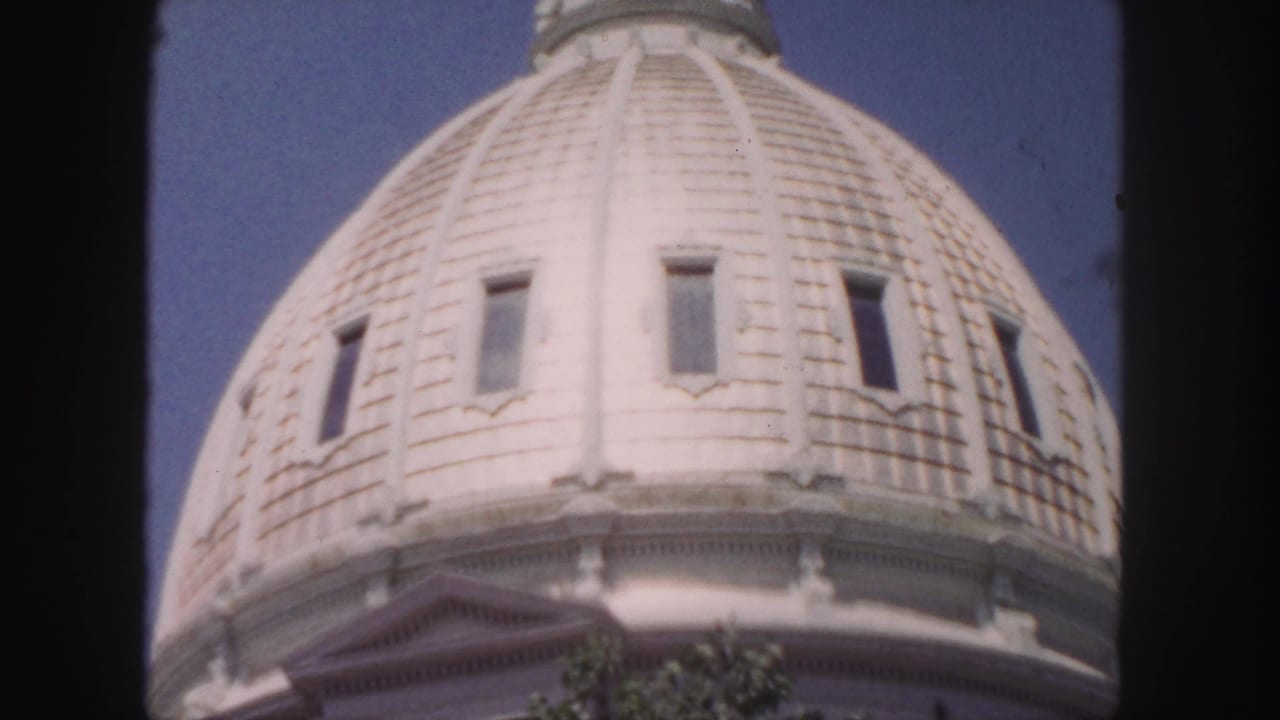 Close view of the same white dome, framed by dark film borders.
