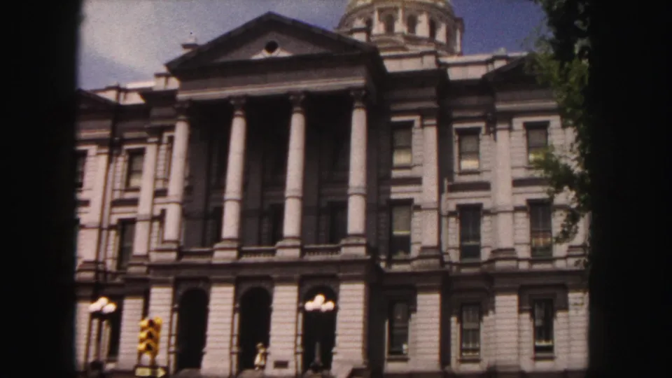 Frontal 1958 Denver view of the Colorado State Capitol facade, showing columns, arched entrances, dome, trees, and street signals.