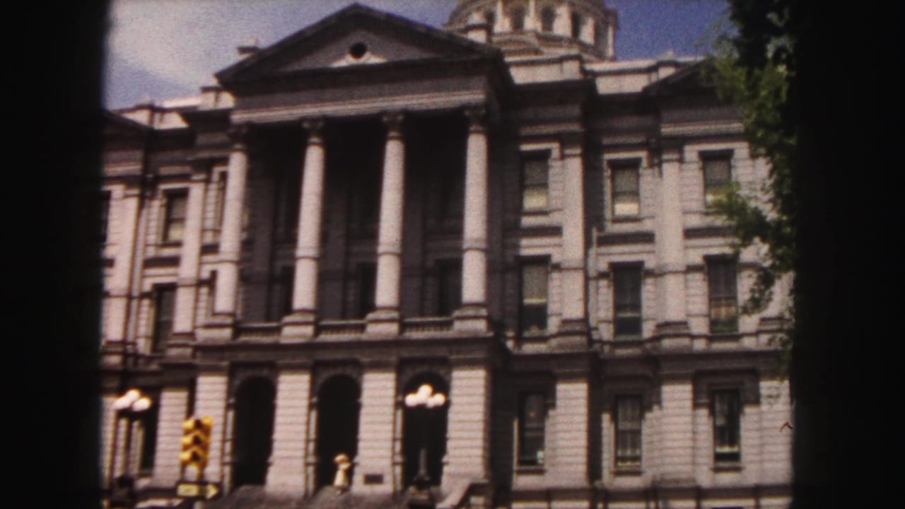 Colorado State Capitol facade with columns, dome, streetlights, and traffic signal.