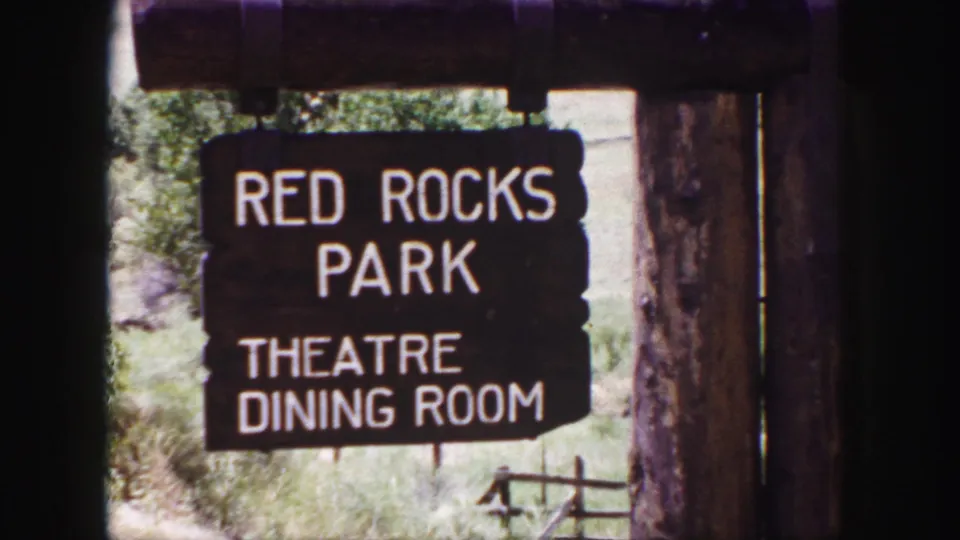1958 Colorado travel frame showing a rustic Red Rocks Park sign for theatre and dining room beneath a wooden beam.