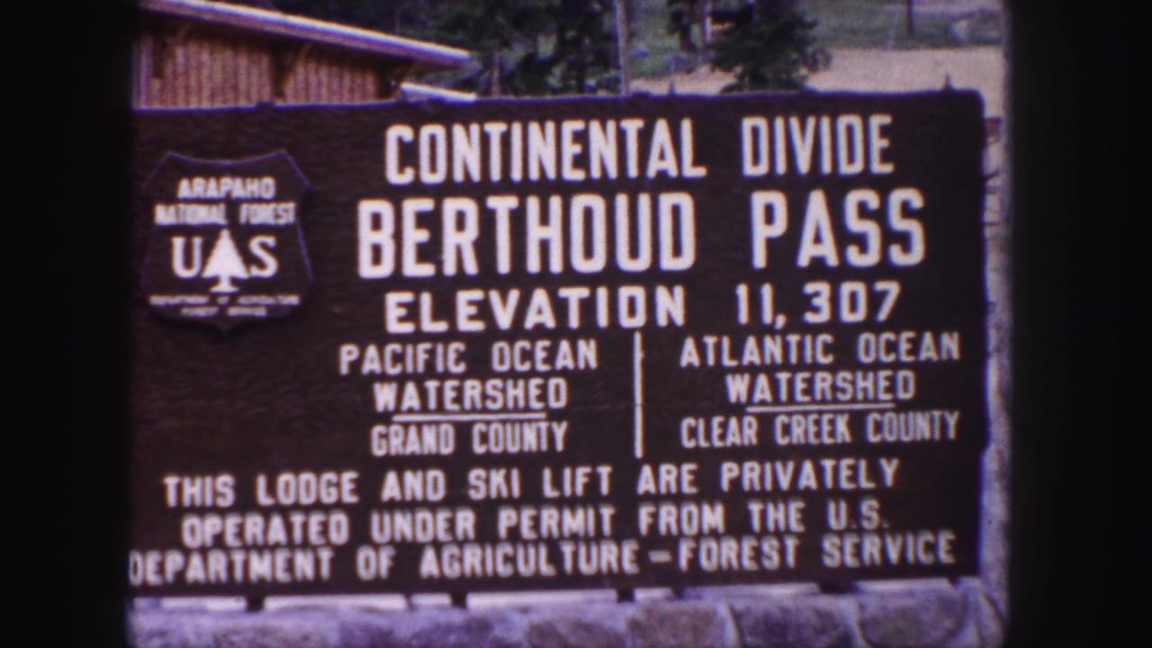 Roadside Berthoud Pass sign with U.S. Forest Service shield and watershed lettering.