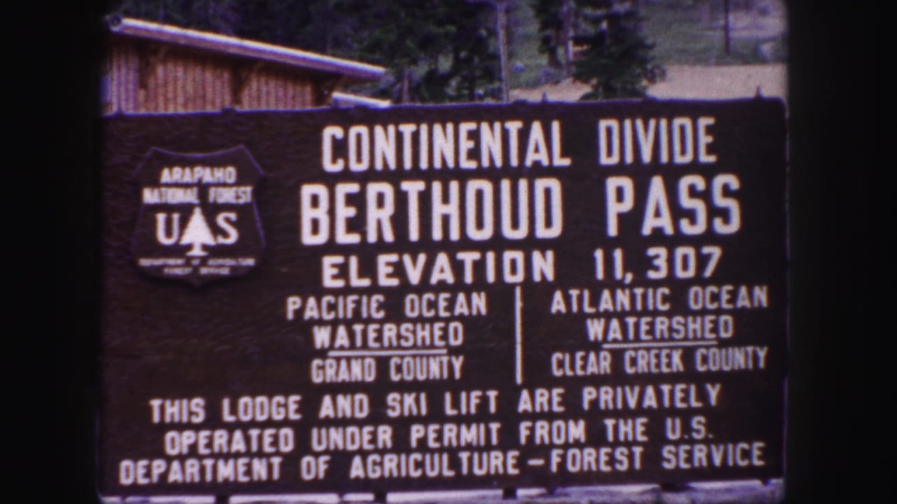 Berthoud Pass Continental Divide sign with elevation and watershed text.