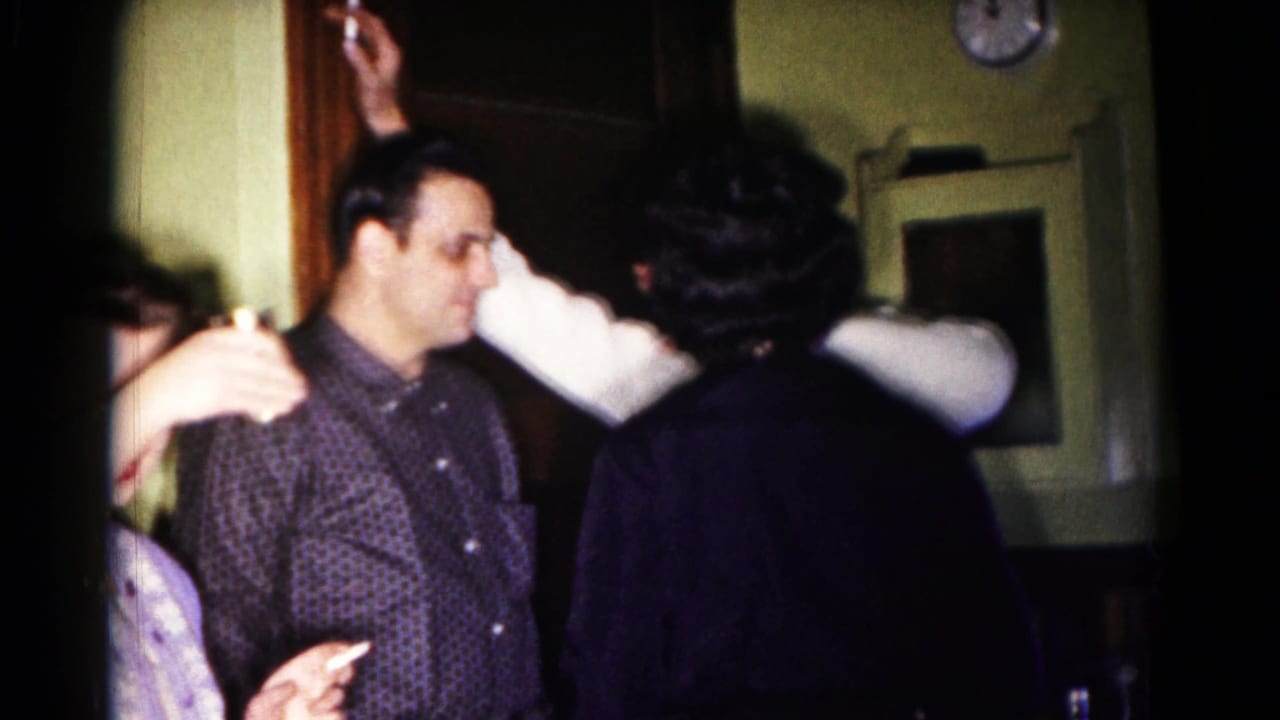 Adults converse inside a Hagerstown, Maryland home in 1958, with a man in a patterned shirt near a wood doorway.