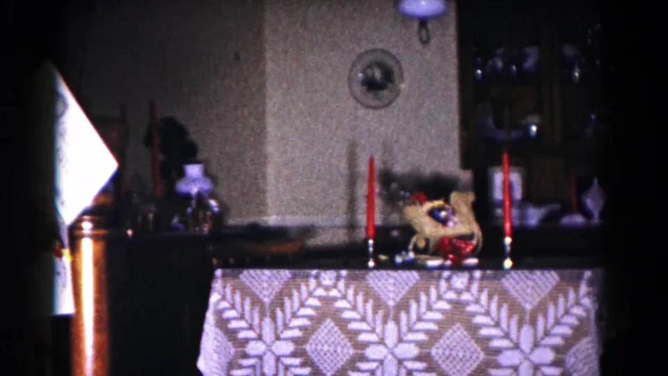Final 1958 Hagerstown frame showing the candlelit table from a slightly shifted angle, with a bright doorway or reflection at left.
