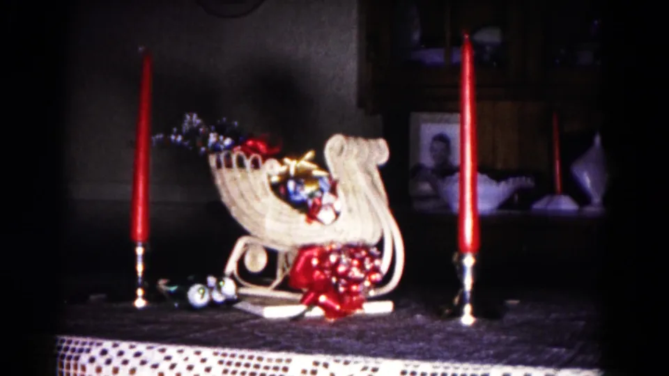 1958 Hagerstown frame showing the tabletop Christmas sleigh arrangement, red candles, lace edge, cabinet, and framed portrait.