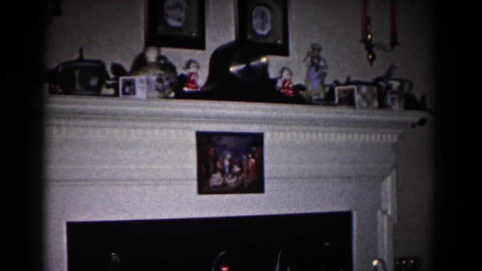 1958 Hagerstown interior frame showing the mantel display from a slightly wider angle with photos, figurines, candles, and hearth.