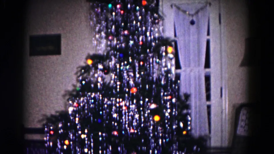 1958 Hagerstown home interior showing the upper and middle Christmas tree with heavy tinsel, lights, curtains, and a small wall picture.