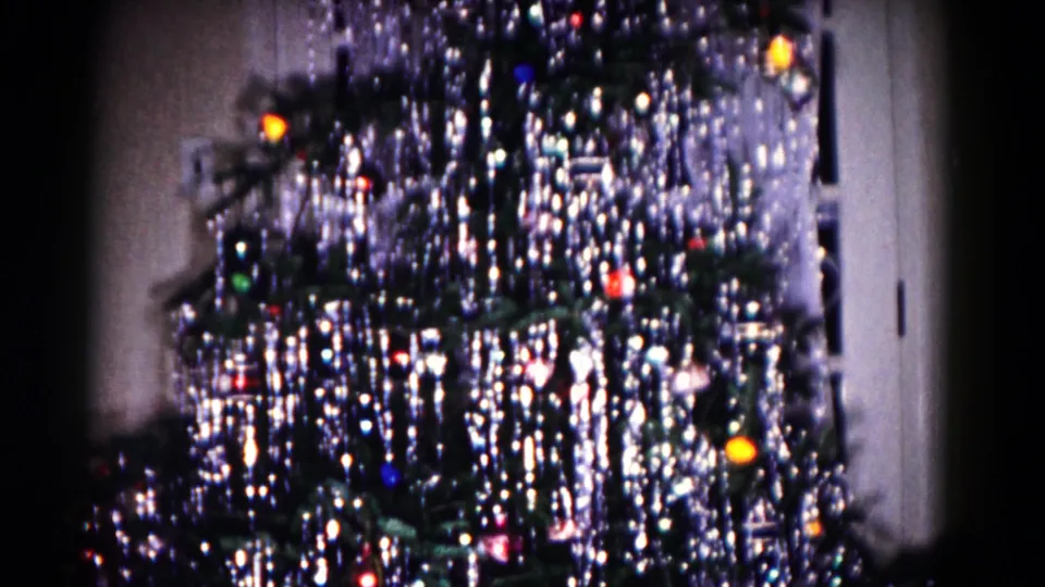 Final 1958 Hagerstown frame showing the decorated tree sliding past a white door and curtain in the background.