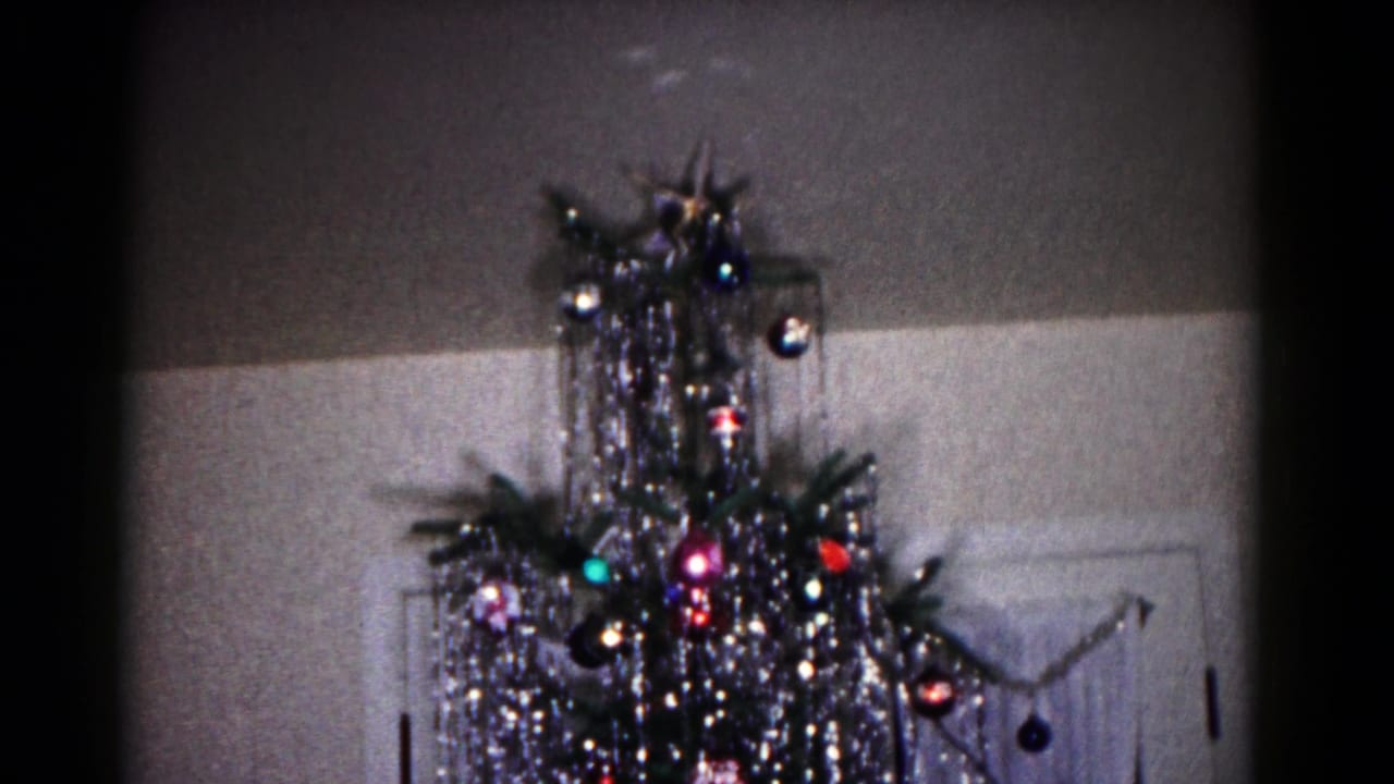 The Hagerstown holiday interior shows a decorated aluminum Christmas tree with shiny ornaments and tinsel against a wall and doorway.