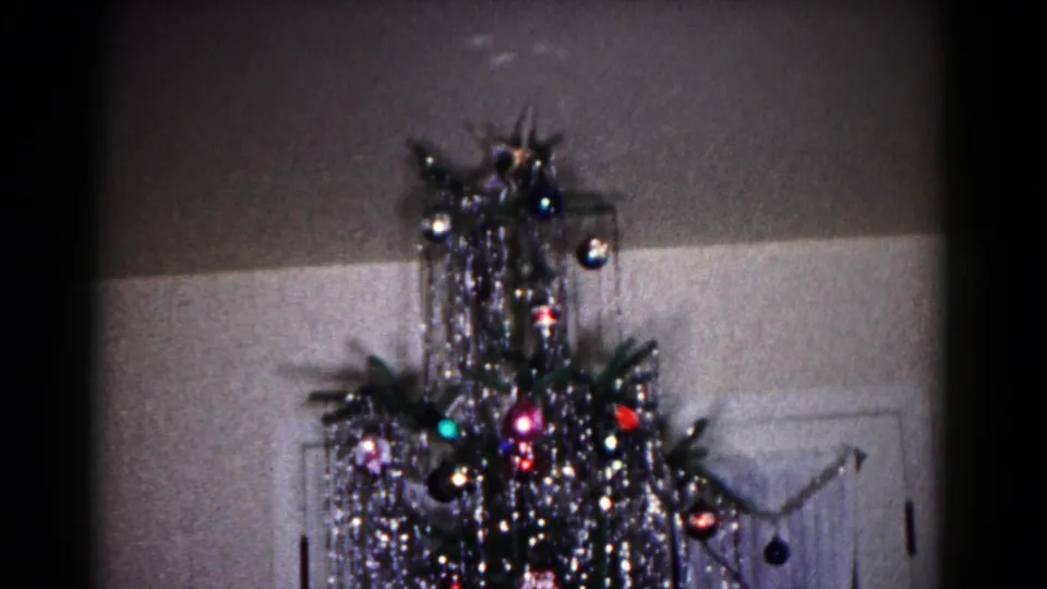 The Hagerstown holiday interior shows a decorated aluminum Christmas tree with shiny ornaments and tinsel against a wall and doorway.