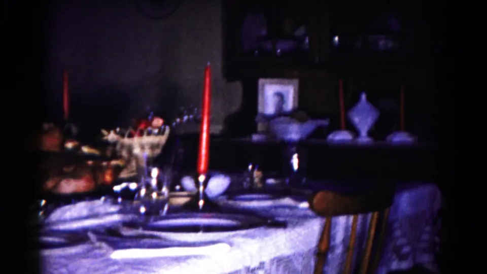 Wider 1958 Hagerstown dining-room view with a set turkey table, red candles, glass serving bowl, and chair.