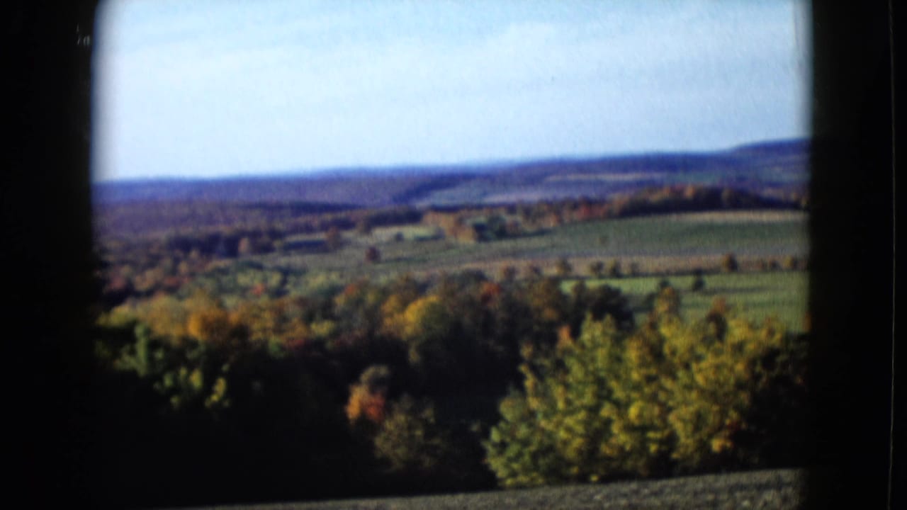1958 8mm home-movie view of rolling countryside, autumn trees, and distant hills near the Las Vegas travel sequence.
