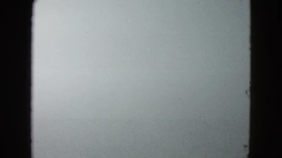 1958 8mm frame from Las Vegas showing dense white fog through a vehicle windshield with dark gate edges.