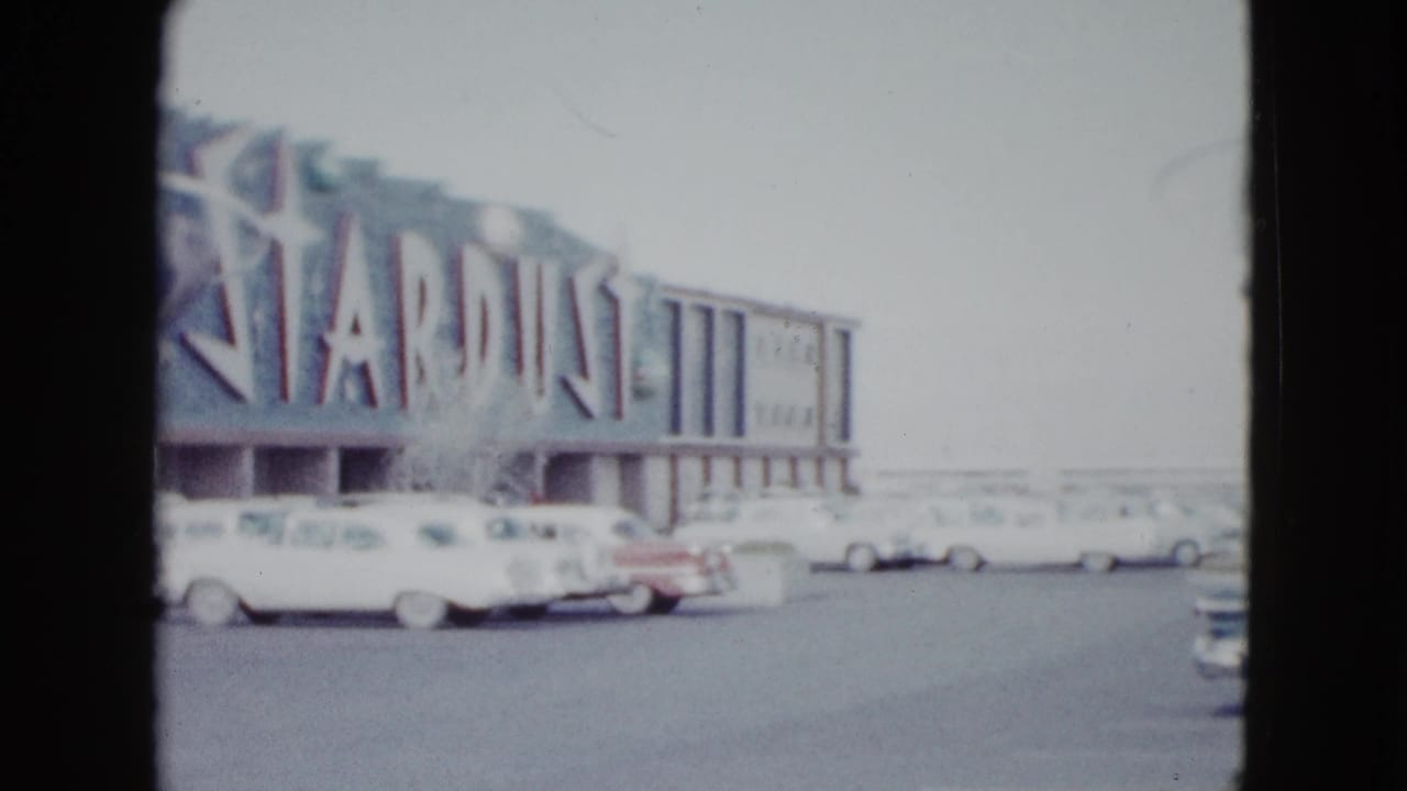 Stardust Hotel facade with classic cars parked in front.