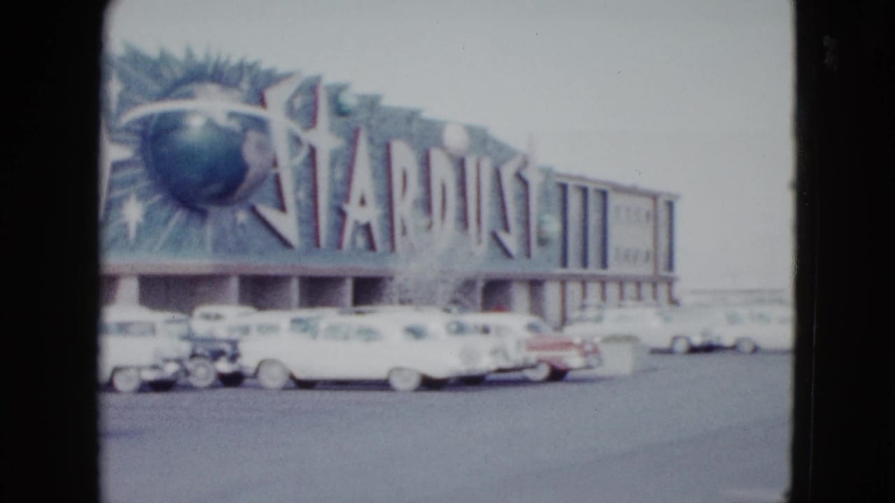 Stardust sign with globe motif above parked cars.