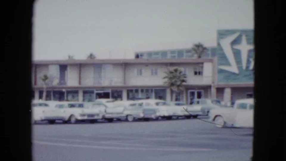 The camera view shifts along the Stardust Hotel frontage, showing parked cars and partial resort signage in Las Vegas.