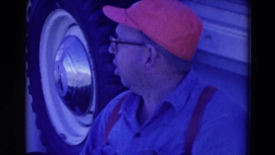 Close home-movie view from Omaha in 1958 showing the man turning toward the truck's whitewall tire and hubcap.