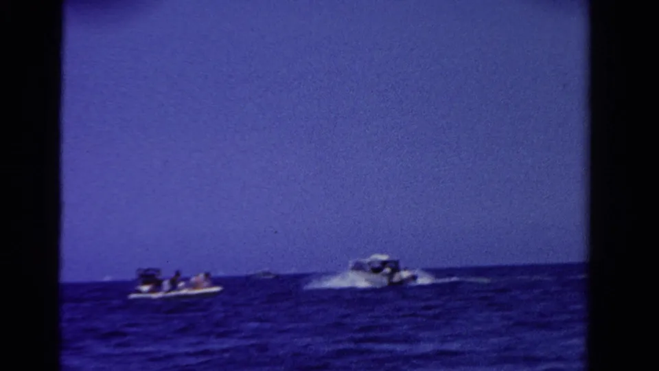 Distant boats on Ontario water in 1958, with passengers visible in one craft and a speedboat throwing spray nearby.