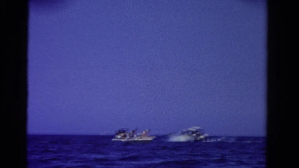 A 1958 Ontario boating scene with small craft traveling across choppy blue water in soft 8mm focus.