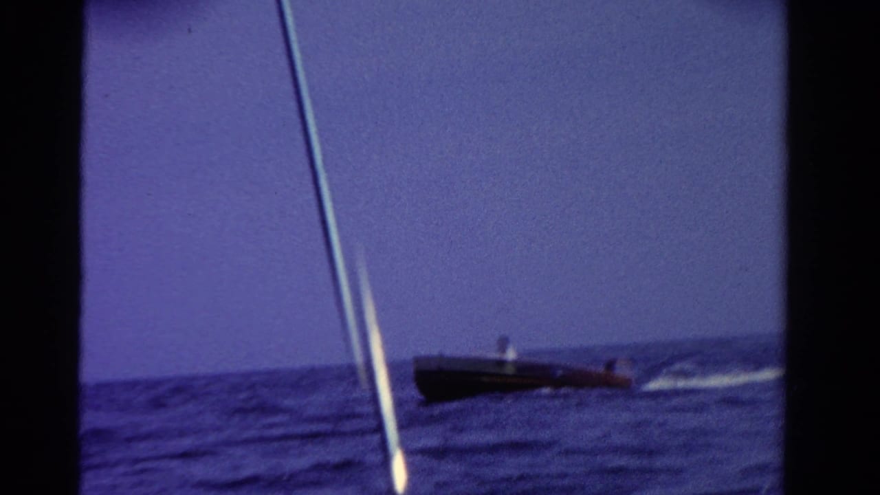 Motorboat moving near the horizon with a white wake behind it.