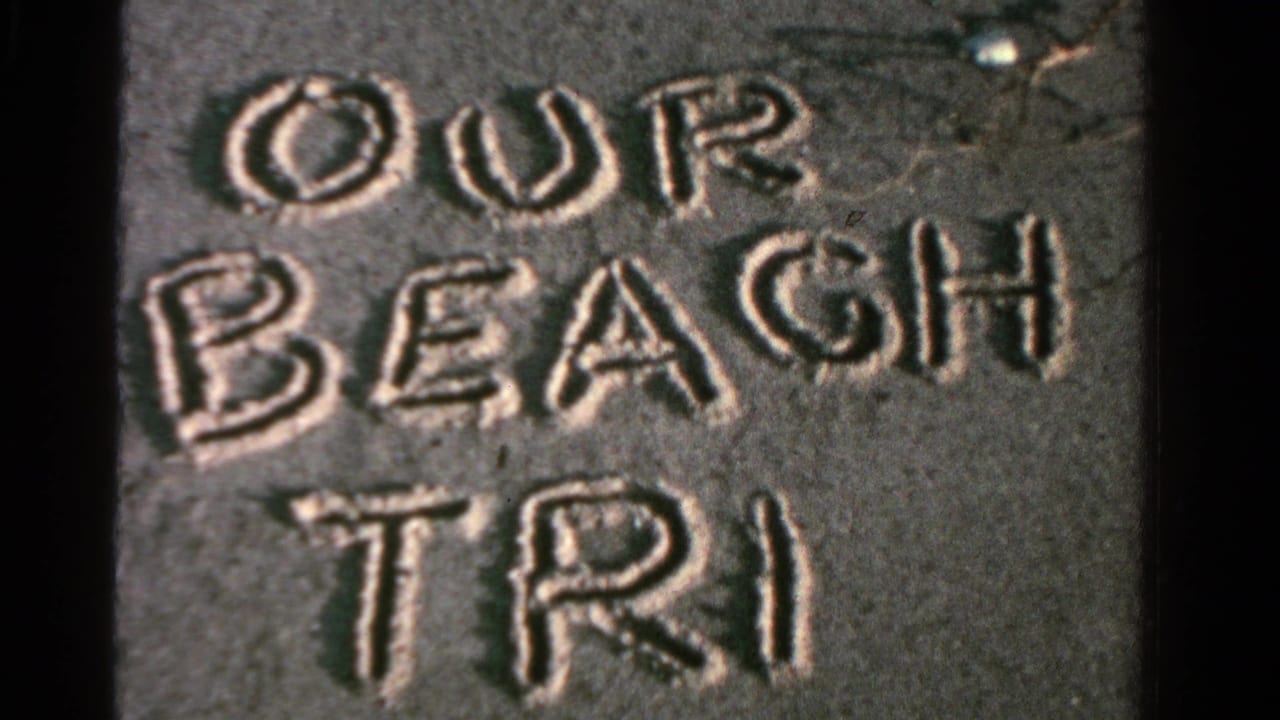 Close view of OUR BEACH TRIP written in sand in 1958 Ontario home-movie footage.