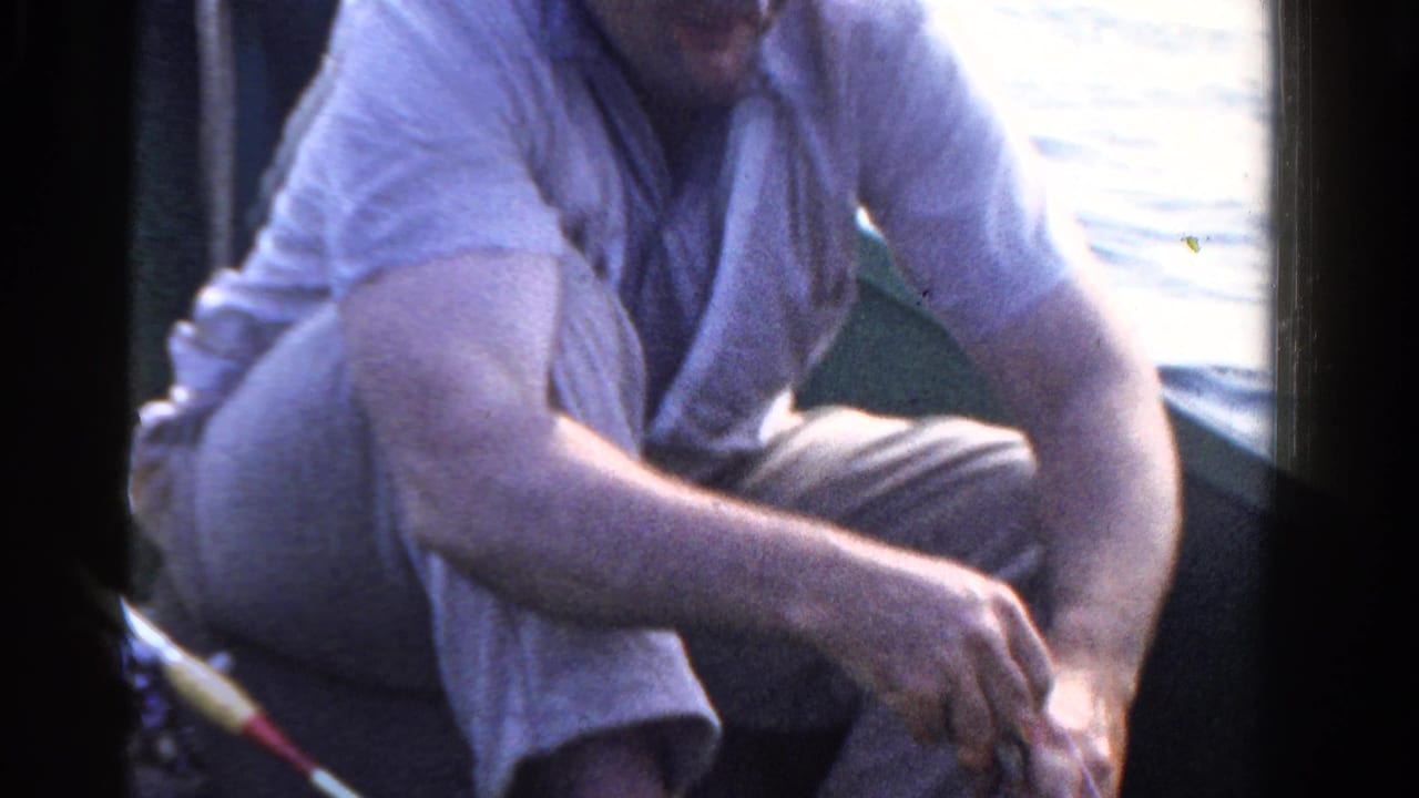 Adult angler in a small Ontario boat appears focused on his fishing rod, with bright water behind him.