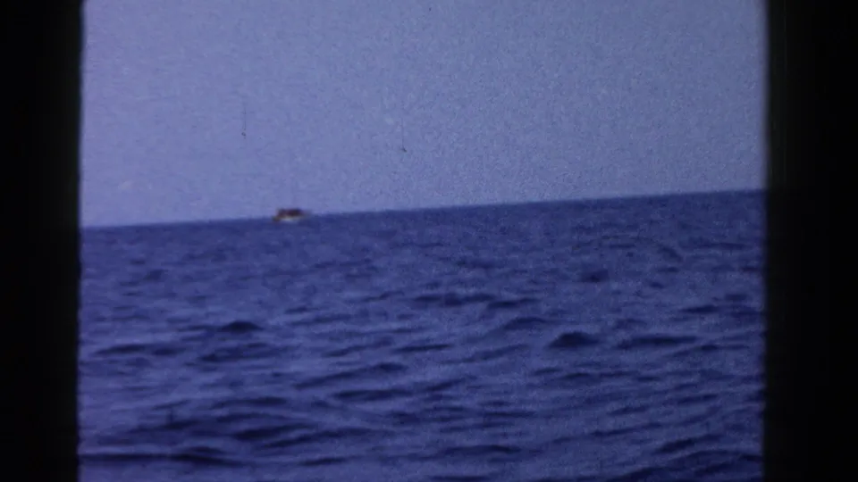 1958 Ontario 8mm view across open blue water, with a small distant vessel near the horizon.