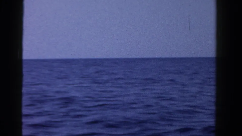 1958 8mm home-movie view of open water in Ontario, Canada, with a low horizon and dark frame edges.