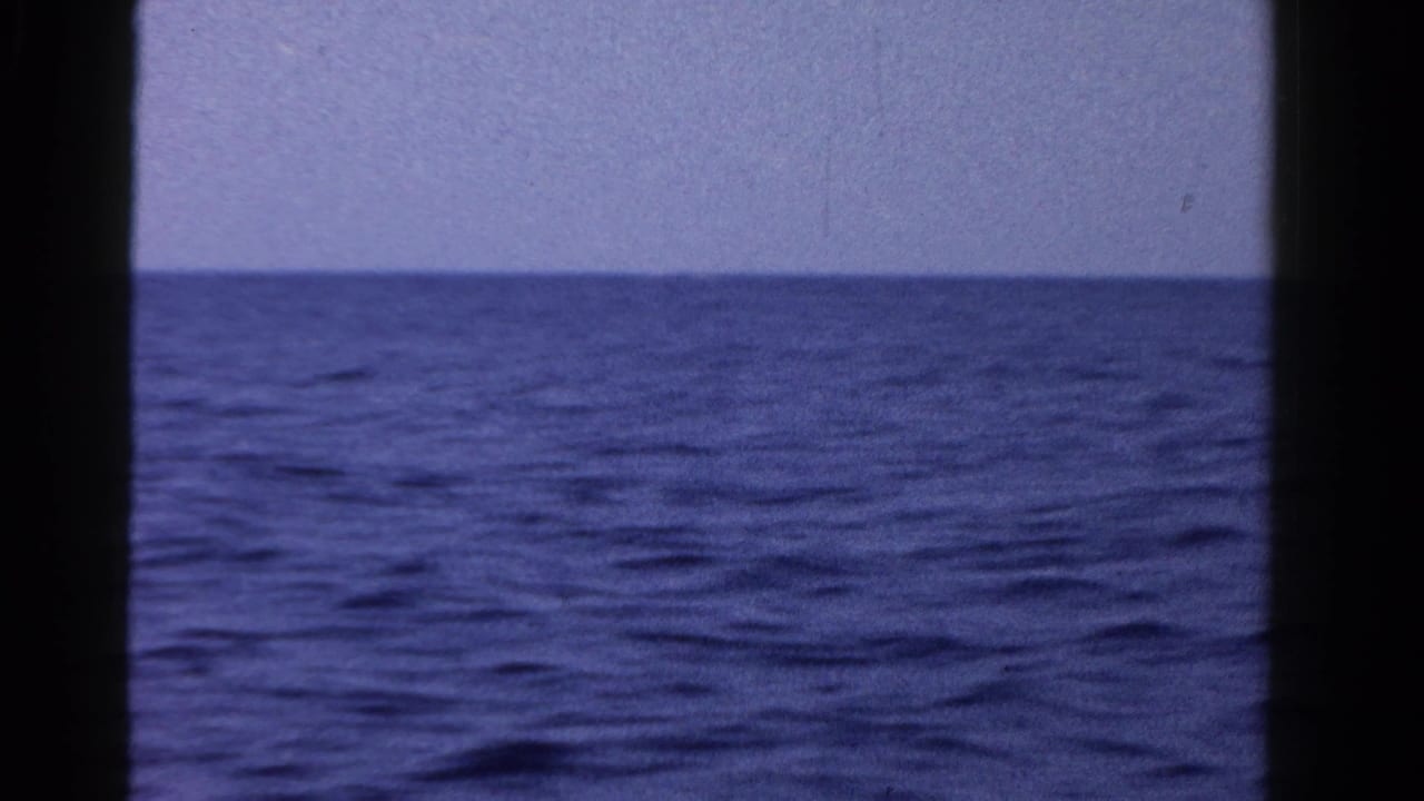 1958 8mm home-movie view of open water and pale sky in Ontario, seen through dark film-frame edges.