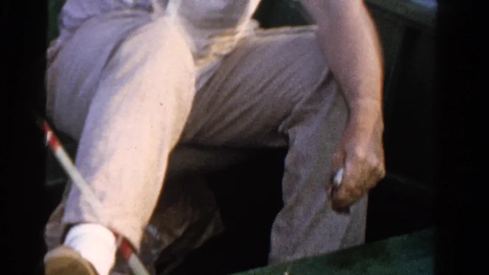 A close 1958 Ontario frame shows the angler seated in the boat, with his hand near fishing gear and rod sections visible.