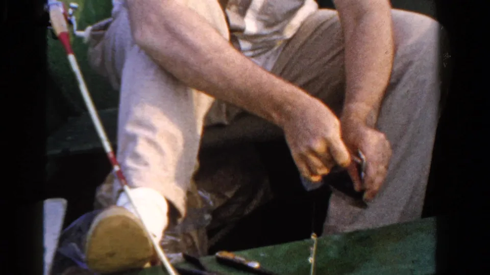 The 1958 Ontario frame shows the angler leaning over his hands as he pulls or adjusts fishing line from the boat.