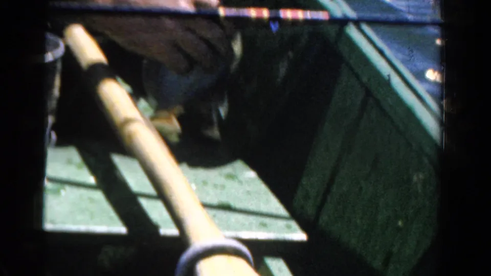 The final frame shows the small boat interior in 1958 Ontario footage, including a green side panel, pale oar or pole, and gear.